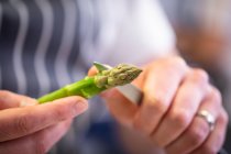 Man holding a green asparagus — Photo de stock