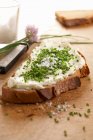 Fatia de pão com queijo creme e cebolinha — Fotografia de Stock