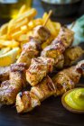Souvlaki grec servi avec pommes de terre frites et sauce moutarde — Photo de stock