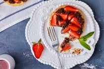 Mini tart with strawberry jam, served with fresh strawberries and chocolate ganache — Stock Photo