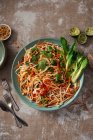 Ensalada de fideos de arroz con brotes de frijol, cilantro, zanahorias, pimiento rojo y pak choi - foto de stock