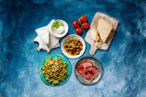 Comida italiana concepto de bocadillos saludables, queso, tomates, setas, aceite de oliva y aceitunas - foto de stock