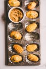 Madeleines with brown sugar on baking tin — Stock Photo