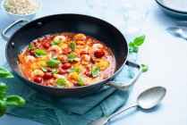 Estofado mediterráneo de pescado y gambas con chorizo, tomates cherry, albahaca y pimentón - foto de stock