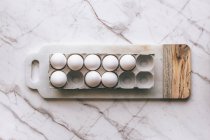 White eggs on marble surface — Stock Photo
