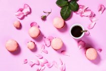 Rosafarbene Makronen mit Rosenblüten und Kaffeetasse — Stockfoto