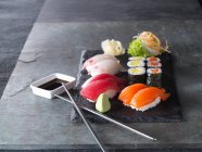 Nigiri sushi y maki con wasabi, salsa de soja y jengibre - foto de stock