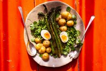 Espargos verdes com ervilhas, batatas e ovos cozidos — Fotografia de Stock