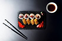 Rolos de sushi com atum, queijo de morango e creme, caramelo de cristal marrom em cima — Fotografia de Stock