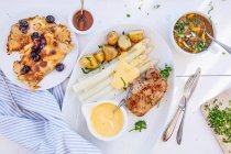 Ein Menü mit Minestrone, Schweinefleisch mit Spargel und Blaubeerpfannkuchen — Stockfoto