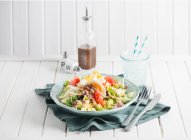 Nizza salad with tuna and egg, soda water with ice in glass — Stock Photo