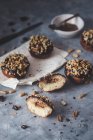Donuts veganos con relleno de caramelo, ganache de chocolate y cacahuetes - foto de stock