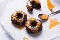 Vegane, im Ofen gebackene SchokoladenDonuts mit Orangenglasur und Orangenschale — Stockfoto