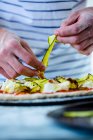 Zubereitung von Pizza mit Zucchini, Mozzarella und Tomatensauce — Stockfoto