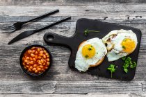 Pancakes with fried eggs and baked beans — Stock Photo