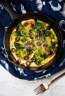 A Socca Pizza with vegetables in a cast iron skillet — Stock Photo