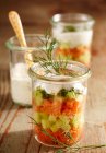 Layered salad in mason jars with smoked salmon, cucumber, dill, yoghurt, lemon, olive oil and horseradish - foto de stock