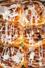 Sourdough cinnamon rolls glazed with icing on a tray — Stock Photo