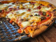 Uma pizza em um grelhador — Fotografia de Stock