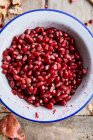 Fresh peeled pomegranate in a white bowl — Photo de stock