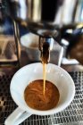 Kaffee fließt aus einer Espressomaschine — Stockfoto