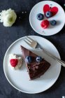 Uma fatia de bolo de chocolate com ganache e bagas frescas — Fotografia de Stock