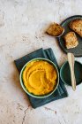 Bowl of hummus with mashed potatoes and croutons on a white wooden background. selective focus. - foto de stock