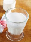 Glass of cold, fresh milk on wooden surface — Stock Photo