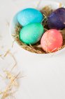 Пасхальные яйца в гнезде на деревянном фоне — стоковое фото