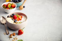 Oat granola with fresh berries, banana, yogurt, chia seeds and mint leaves — Stock Photo