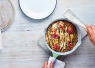 Cropped shot of female hands putting pizza at home — Stock Photo