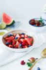 Salada de frutas de verão com bagas e melancia na tigela na mesa — Fotografia de Stock