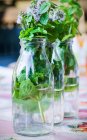 Herbes sauvages dans une bouteille d'eau comme décoration de table — Photo de stock