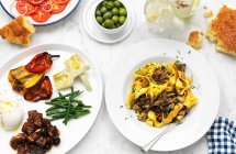 Italienische Antipasti und Pappardelle mit Pilzen — Stockfoto