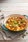 Spring casserole with chicken tights, new potatoes, baby carrots, young cabbage, broad beans and sage — Stock Photo