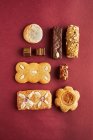 Various gingerbread biscuits on red paper, top view — Stock Photo