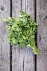 Fresh parsley bunch on rustic wooden surface — Stock Photo