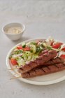 Close-up shot of delicious Grilled lamb skewers with salad — Stock Photo