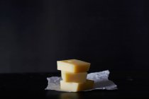 Pilha de três fatias de queijo Emmental em papel — Fotografia de Stock