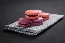 Lila und rosa Macarons auf gestreifter Stoffserviette — Stockfoto