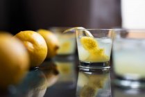 Limoncello com cubos de gelo e casca de limão fresca — Fotografia de Stock