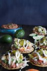 Chicken tostadas with jalapeno peppers, black olives, sour cream, lettuce, shredded chicken and fresh cilantro — Stock Photo