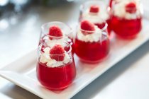 Jelly glass shots avec crème fouettée et framboises fraîches — Photo de stock