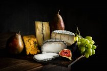 Selección de queso con uvas, higos y pera - foto de stock