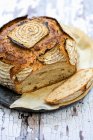 Pan de masa fermentada con rodajas en la superficie rústica - foto de stock