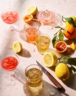 Summer Mixed Cocktails with fresh lemons, oranges and leaves — Stock Photo