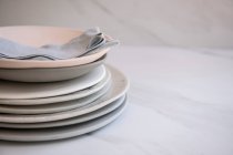 Plate Stacked On Marble surface with cloth napkin — Stock Photo