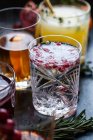 Diverses boissons alcoolisées avec whisky, bourbon, vodka, canneberge, oranges, grenades, romarin et thym — Photo de stock