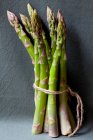 Fresh green asparagus on a dark background. — Stock Photo