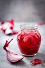 Rote Chilischote in einem Glas auf einem hölzernen Hintergrund. Selektiver Fokus. — Stockfoto